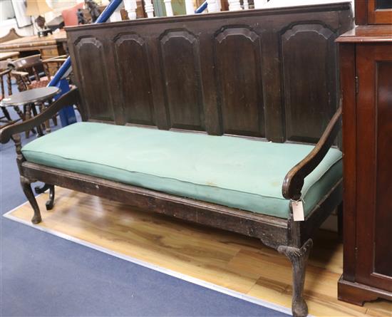 An 18th century oak settle, with panelled back, W.184cm H.114cm